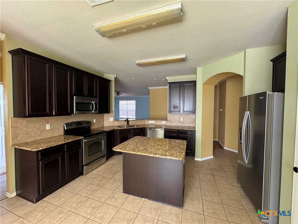 6801 Modesto Road Killeen, TX 76542 - Photo 7 of 26 a kitchen with a sink a counter top space and stainless steel appliances