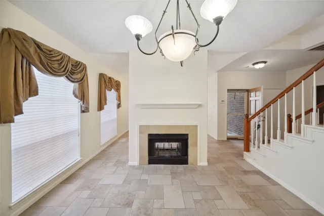 a view of a livingroom with an empty kitchen and a fireplace