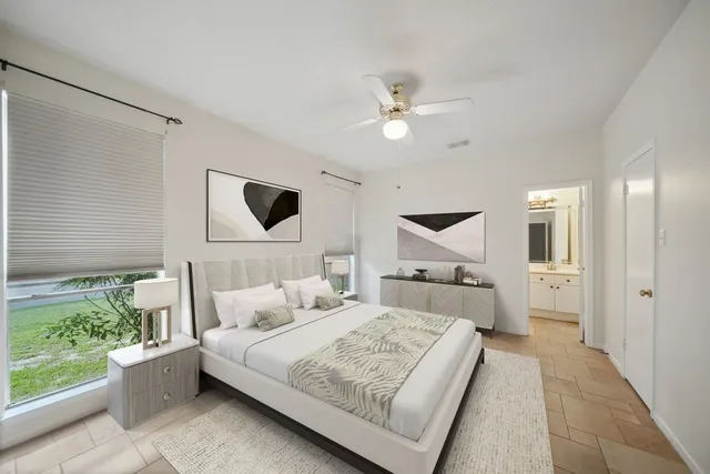 a bedroom with a large bed and ceiling fan