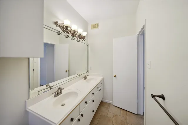 a bathroom with a double vanity sink and a mirror