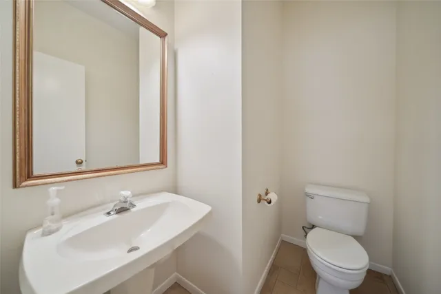 a bathroom with a sink a toilet and mirror