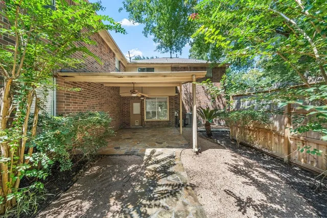 a view of a patio with table and chairs and a large tree