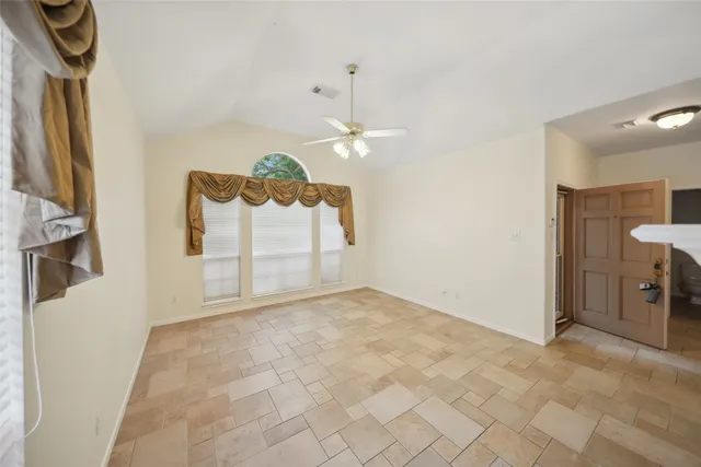 a view of a room with a chandelier fan and windows