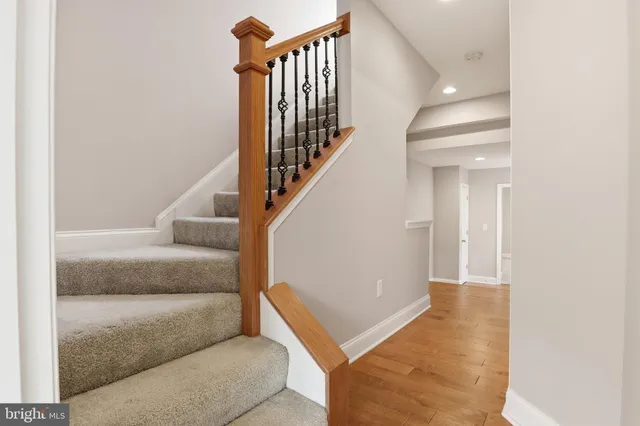 a view of a hallway with white walls and stairs