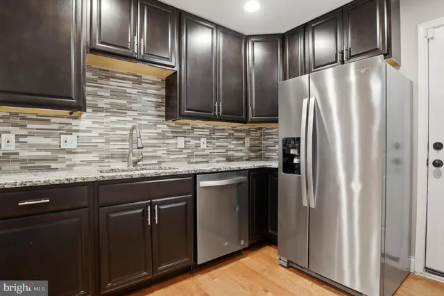 a kitchen with stainless steel appliances granite countertop a refrigerator a stove a sink and a microwave