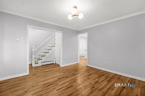 634 Newhall Street Hamden, CT 06517 - Photo 4 of 28 a view of an empty room with wooden floor and a ceiling fan