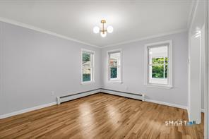634 Newhall Street Hamden, CT 06517 - Photo 5 of 28 an empty room with wooden floor chandelier and windows
