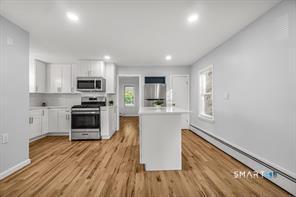 634 Newhall Street Hamden, CT 06517 - Photo 9 of 28 a kitchen with wooden floors and appliances