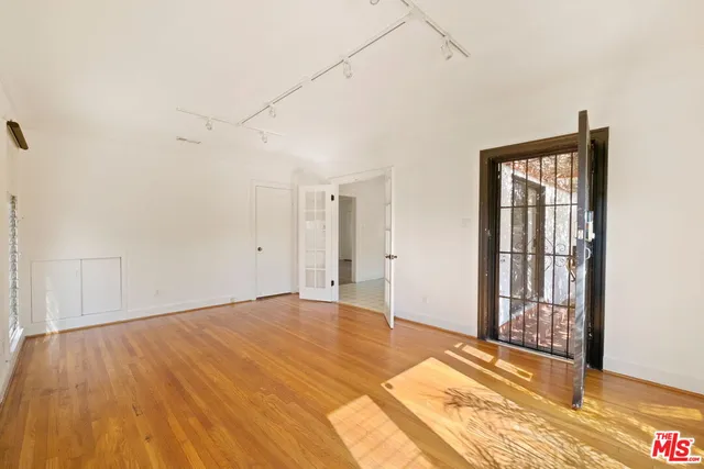 a view of an empty room with wooden floor