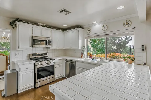 a kitchen with stainless steel appliances granite countertop a stove a sink and a microwave
