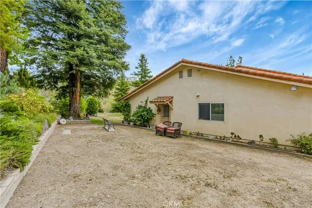 a backyard of a house with table and chairs under an umbrella