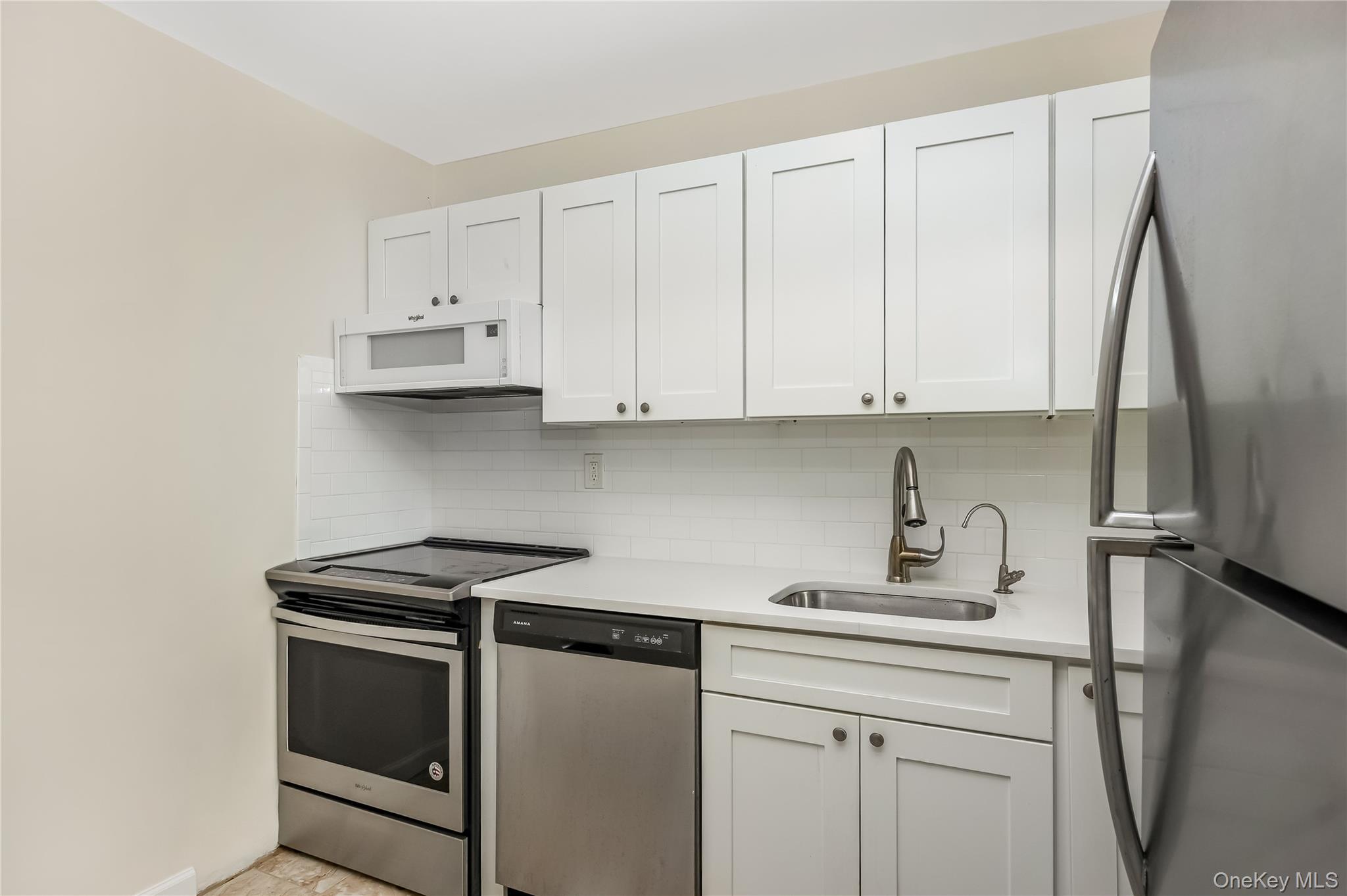 2 Richmond Road, Unit 6M Lido Beach, NY 11561 - Photo 12 of 21 a kitchen with stainless steel appliances white cabinets and a sink