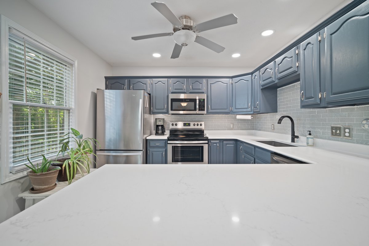 2606 Persimmon Place Bloomington, IL 61701 - Photo 6 of 19 a kitchen with stainless steel appliances a refrigerator a sink a stove a microwave and wooden cabinets