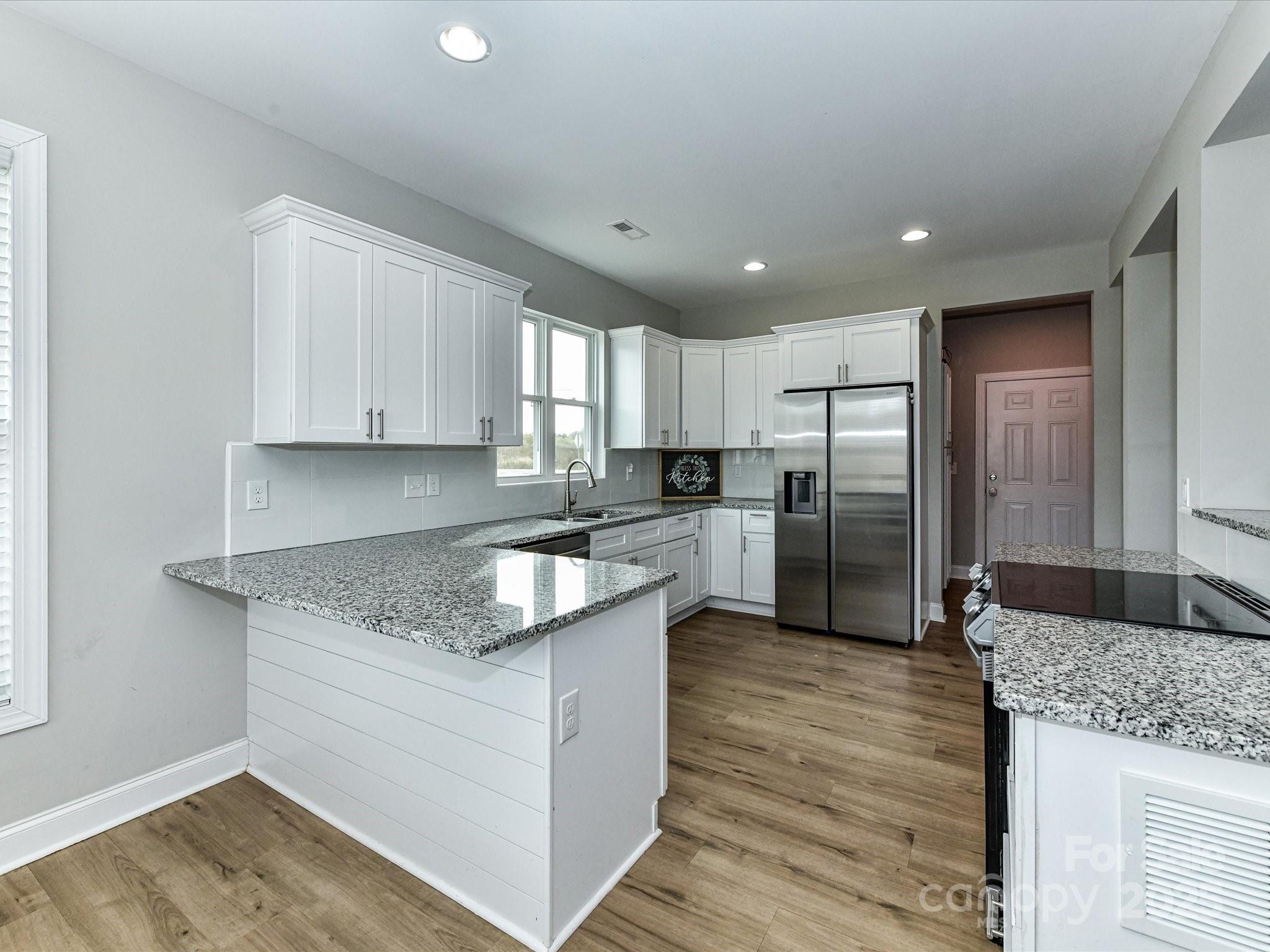 899 Hasty Road Marshville, NC 28103 - Photo 14 of 44 a kitchen with stainless steel appliances granite countertop a sink stove and refrigerator
