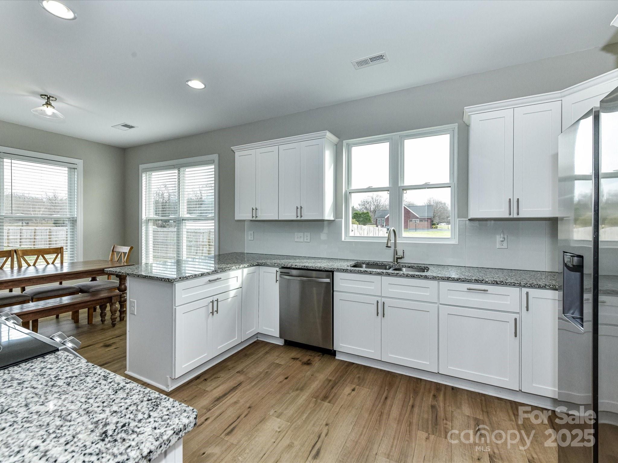899 Hasty Road Marshville, NC 28103 - Photo 15 of 44 a kitchen with stainless steel appliances granite countertop a stove a sink dishwasher and a microwave oven with white cabinets