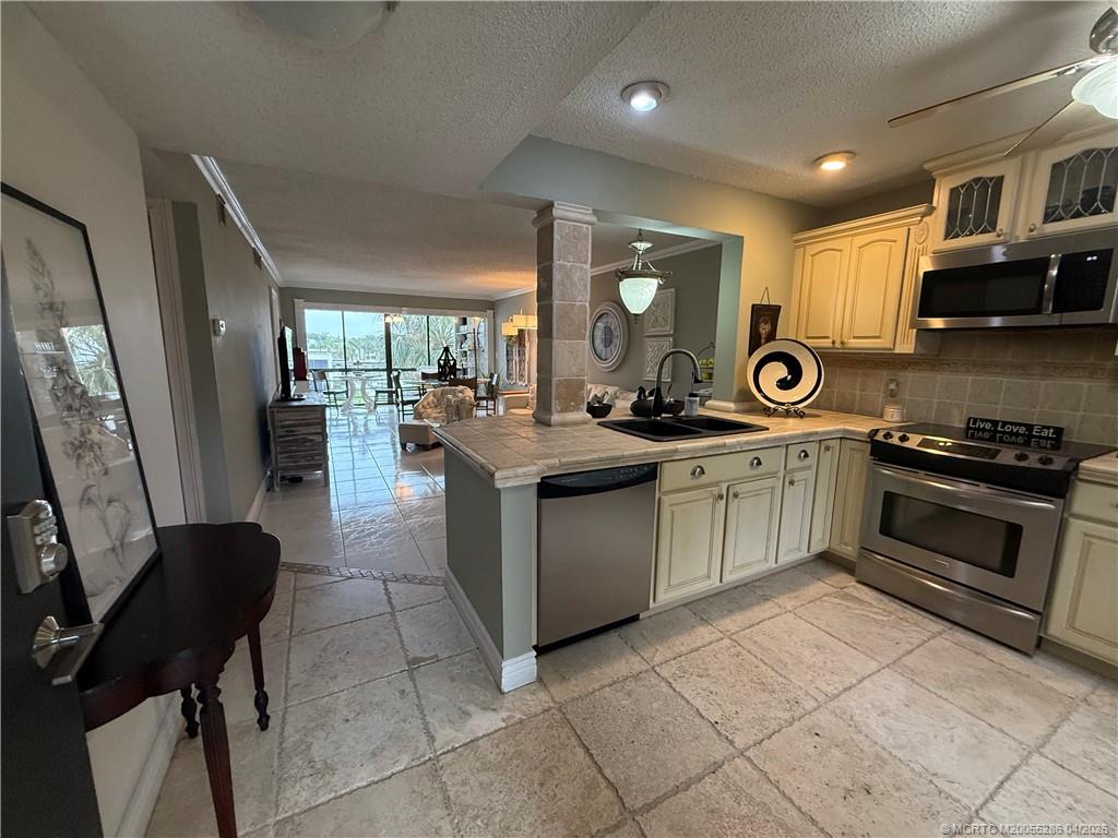 1950 Southwest Palm City Road, Unit 3306 Stuart, FL 34994 - Photo 13 of 49 a kitchen with stainless steel appliances granite countertop a stove top oven a sink a counter space and cabinets