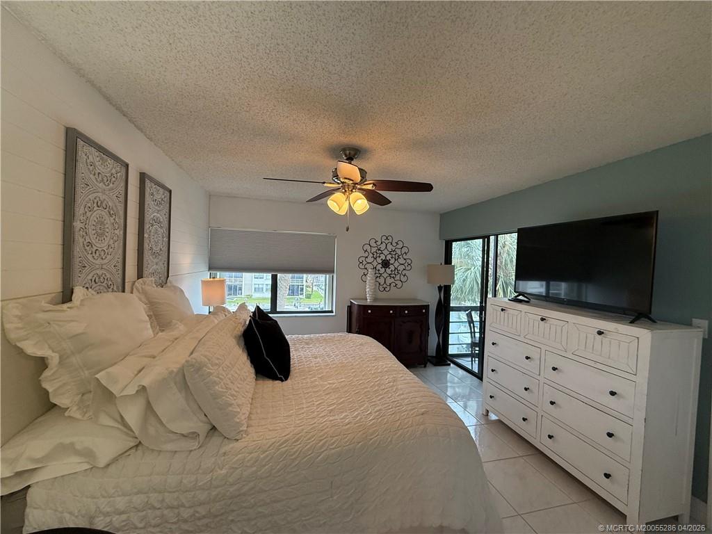 1950 Southwest Palm City Road, Unit 3306 Stuart, FL 34994 - Photo 23 of 49 a bedroom with a bed and a flat screen tv