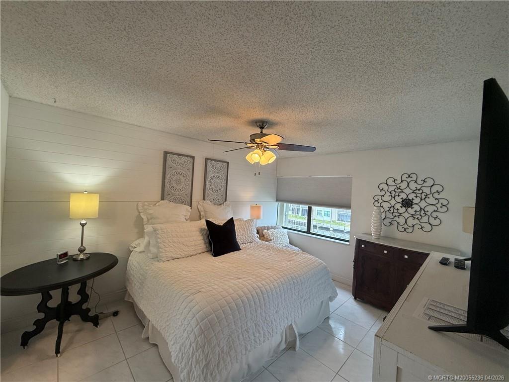 1950 Southwest Palm City Road, Unit 3306 Stuart, FL 34994 - Photo 25 of 49 a bedroom with a bed and a chandelier