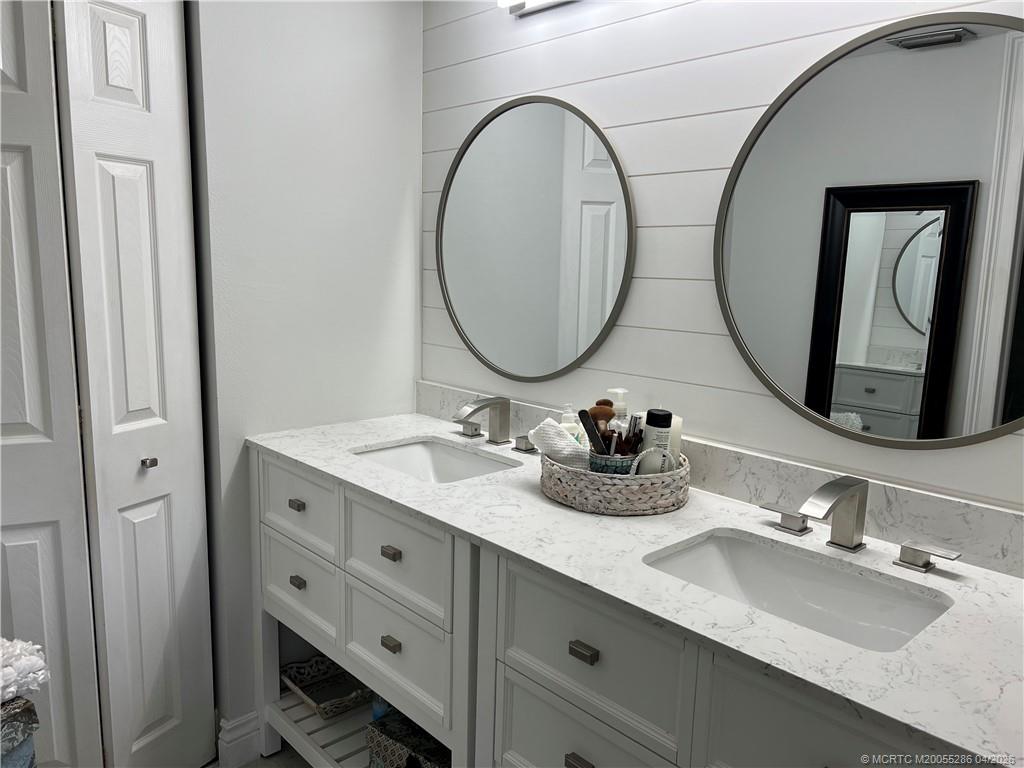 1950 Southwest Palm City Road, Unit 3306 Stuart, FL 34994 - Photo 28 of 49 a bathroom with a double vanity sink and a mirror