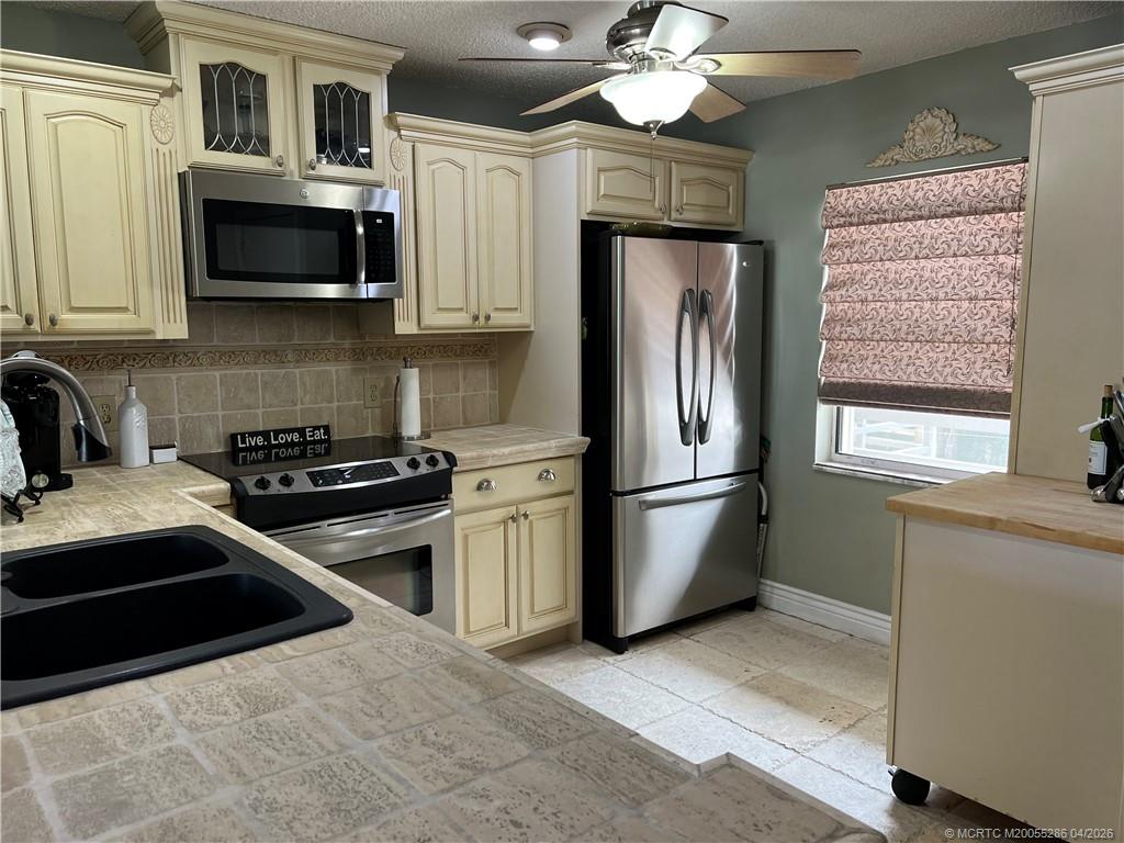 1950 Southwest Palm City Road, Unit 3306 Stuart, FL 34994 - Photo 10 of 49 a kitchen with stainless steel appliances granite countertop a refrigerator a stove a sink and a microwave