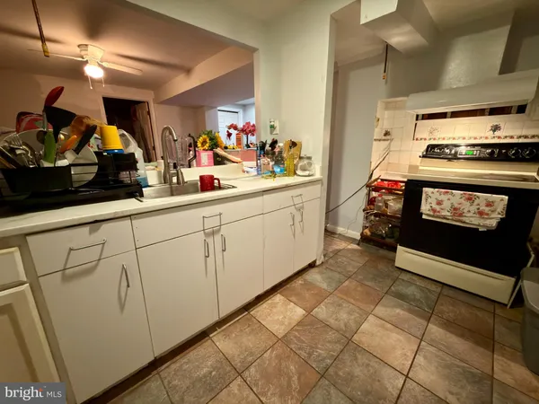 a kitchen with sink cabinets and flat screen tv