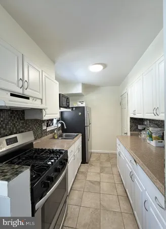 a kitchen with a stove a sink and a refrigerator
