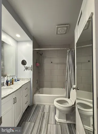 a bathroom with a bathtub shower sink mirror and toilet