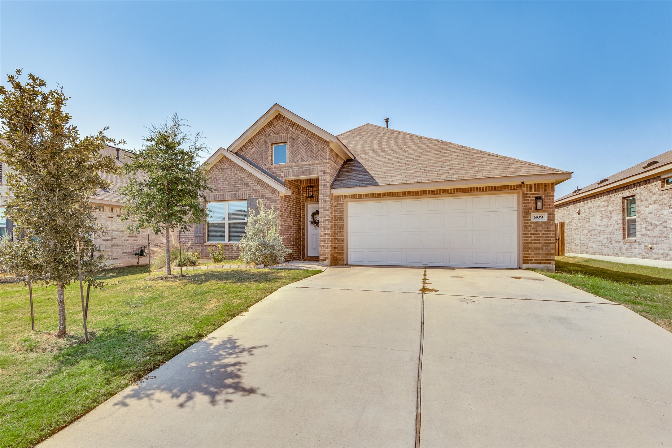 809 San Marcos Street Manor, TX 78653 - Photo 1 of 25 a front view of a house with a yard and garage