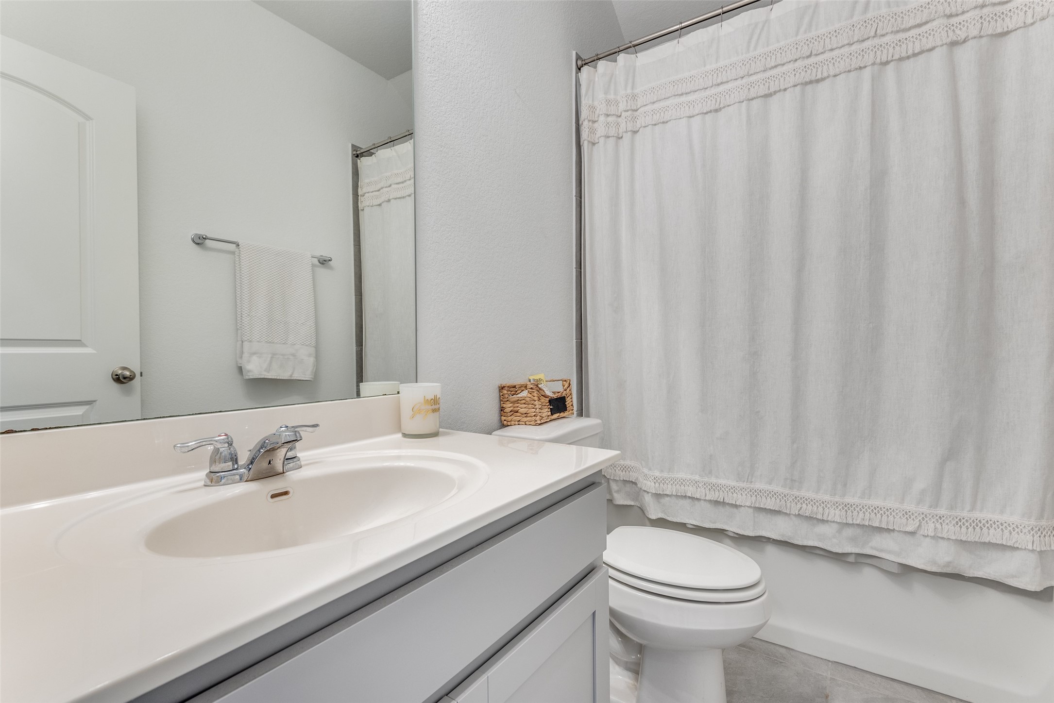809 San Marcos Street Manor, TX 78653 - Photo 14 of 25 a bathroom with a sink a toilet and shower curtain