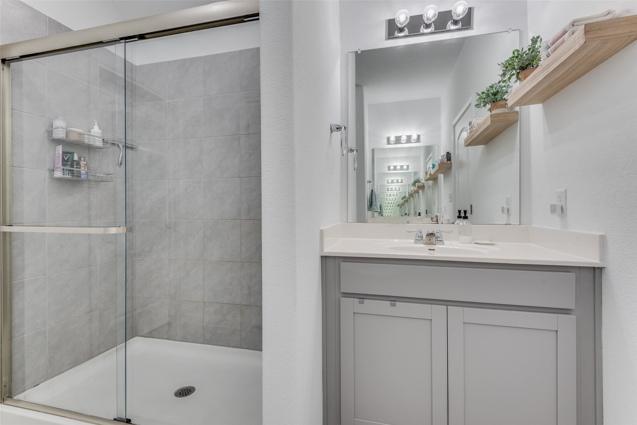 809 San Marcos Street Manor, TX 78653 - Photo 18 of 25 a bathroom with a shower sink and mirror