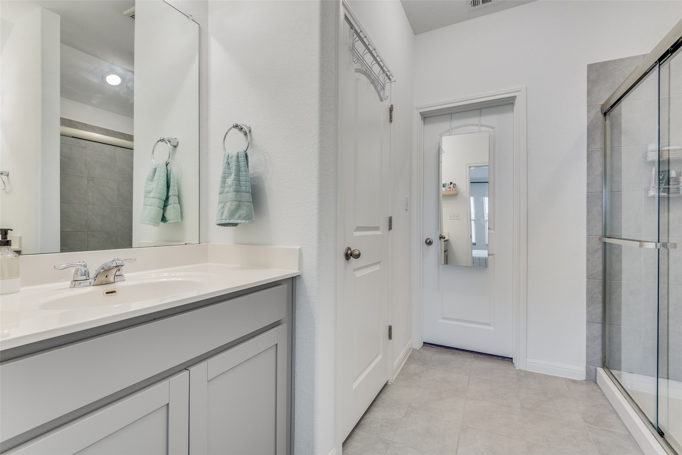 809 San Marcos Street Manor, TX 78653 - Photo 19 of 25 a spacious bathroom with a granite countertop sink and a mirror