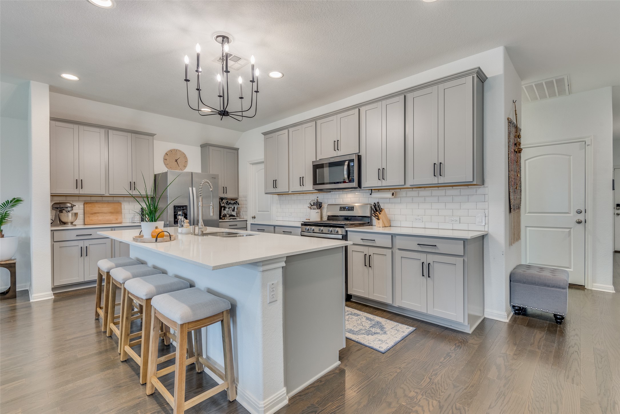 809 San Marcos Street Manor, TX 78653 - Photo 6 of 25 a kitchen with kitchen island granite countertop a sink cabinets and stainless steel appliances