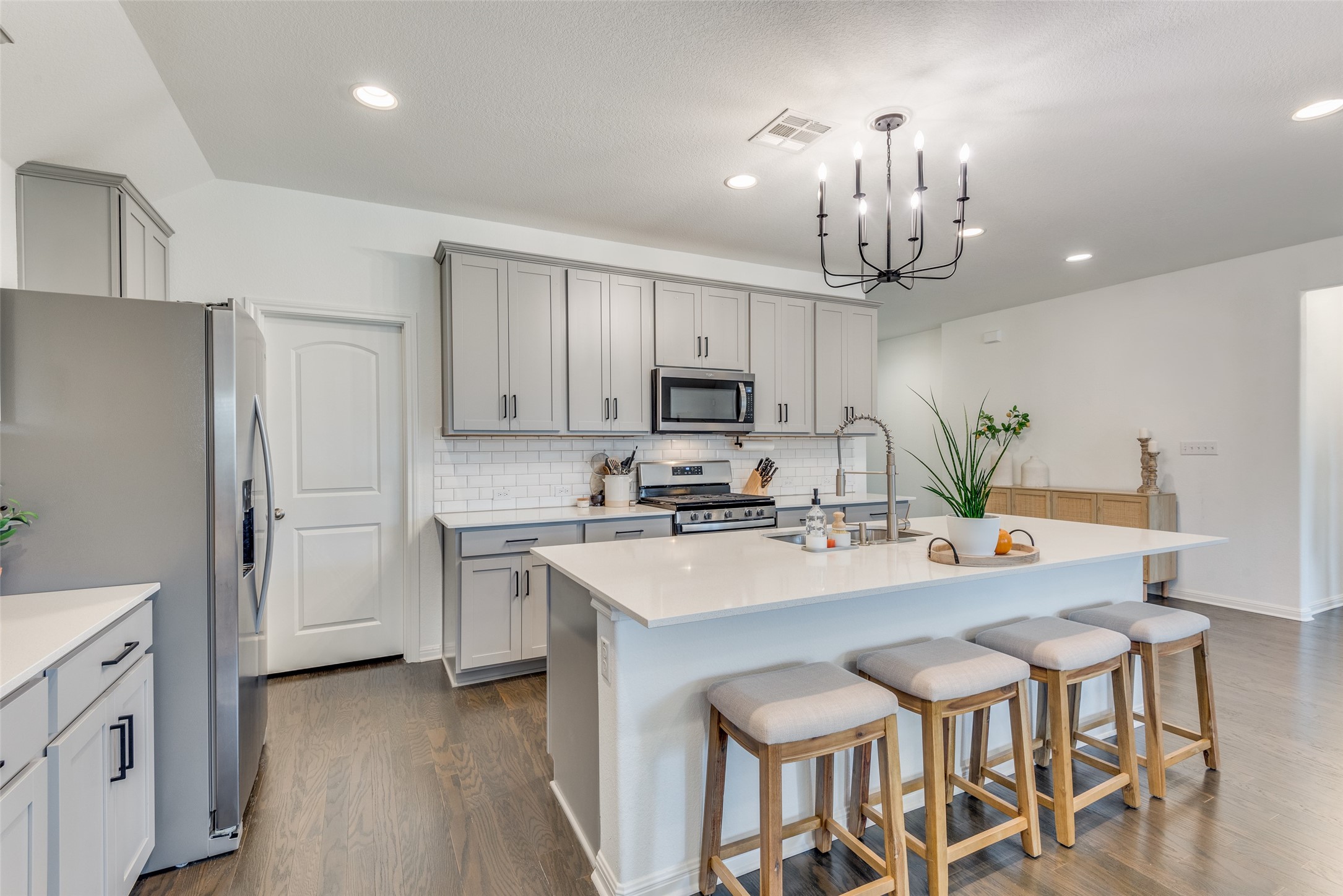 809 San Marcos Street Manor, TX 78653 - Photo 9 of 25 a kitchen with granite countertop a sink stove and refrigerator
