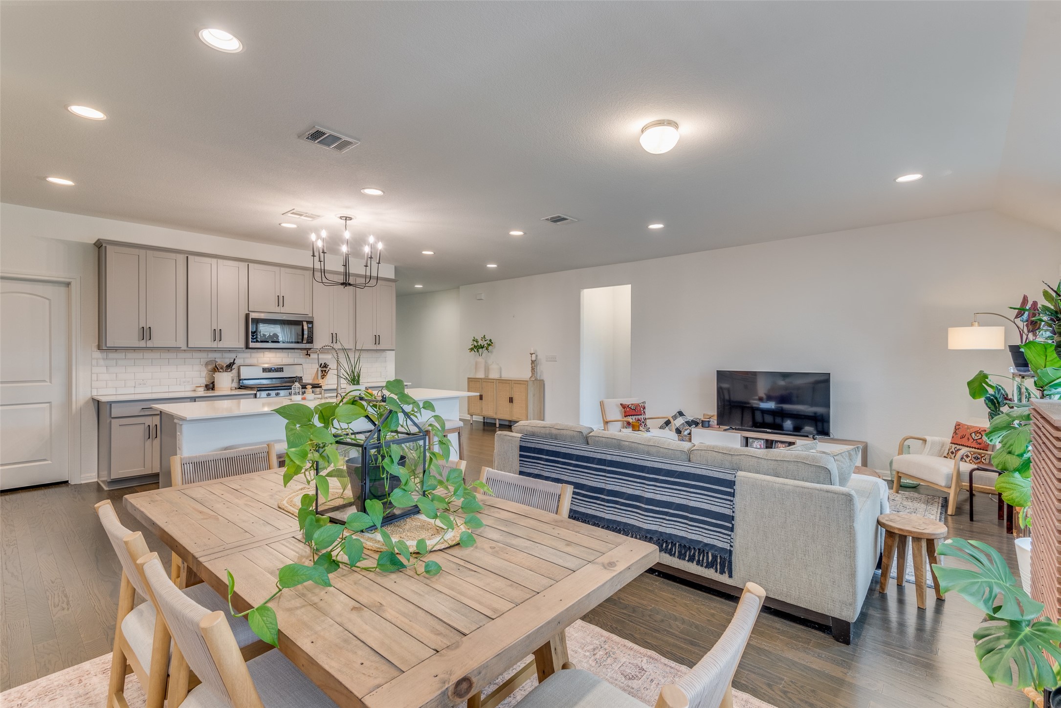 809 San Marcos Street Manor, TX 78653 - Photo 10 of 25 a kitchen with a refrigerator and a dining table with wooden floor