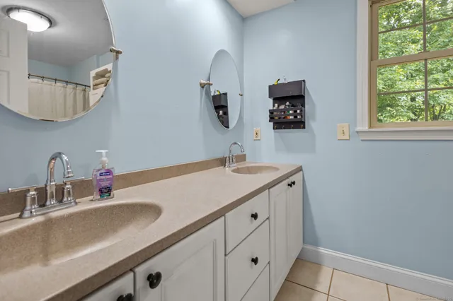 a bathroom with a double vanity sink and a mirror