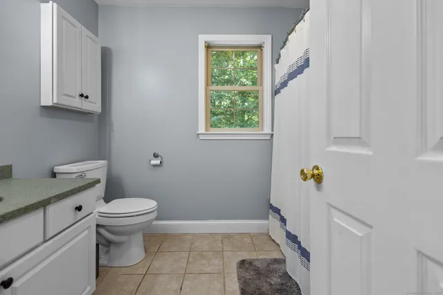 a bathroom with a sink a toilet and a window