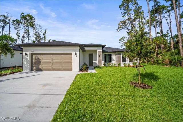 a front view of a house with a yard and garage