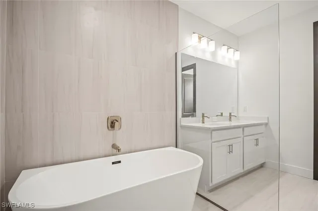 a bathroom with a bathtub a sink and a mirror