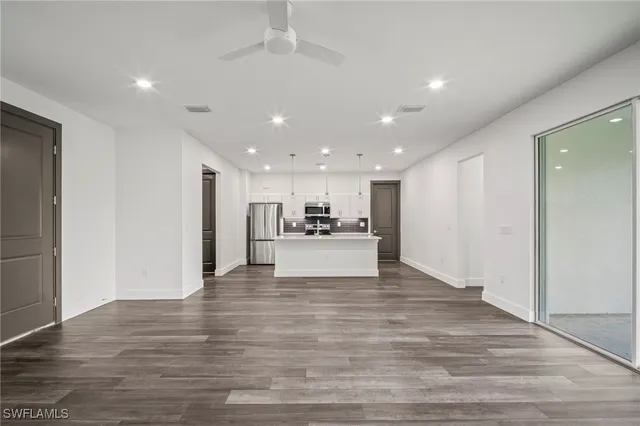 a view of kitchen with kitchen island white cabinets and refrigerator