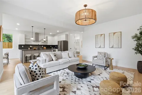 a kitchen with stainless steel appliances granite countertop a stove top oven a sink a dining table and chairs with wooden floor