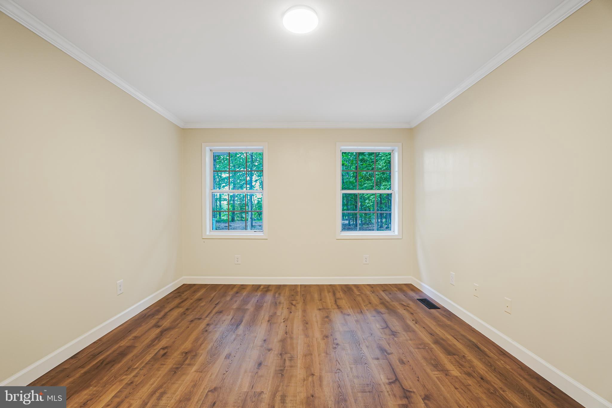 767 Loving Road Zion Crossroads, VA 22942 - Photo 23 of 33 an empty room with wooden floor and windows