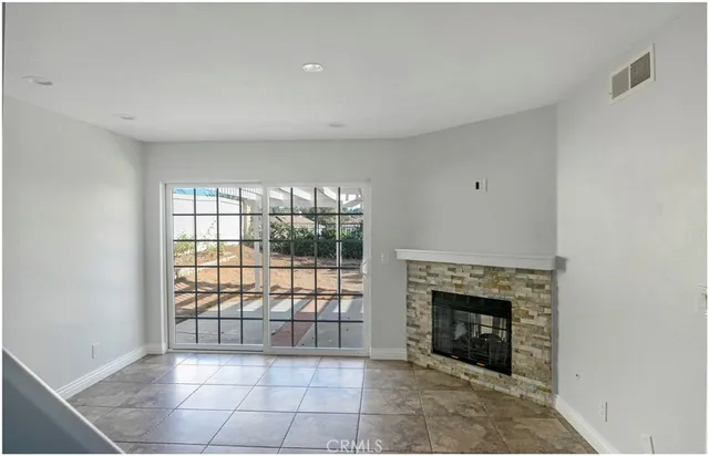 a view of a livingroom with a fireplace and window