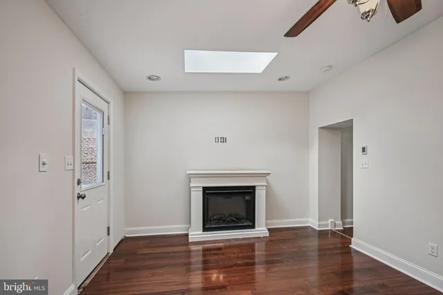 an empty room with wooden floor and fireplace
