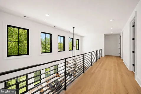 a view of hallway with wooden floor and windows