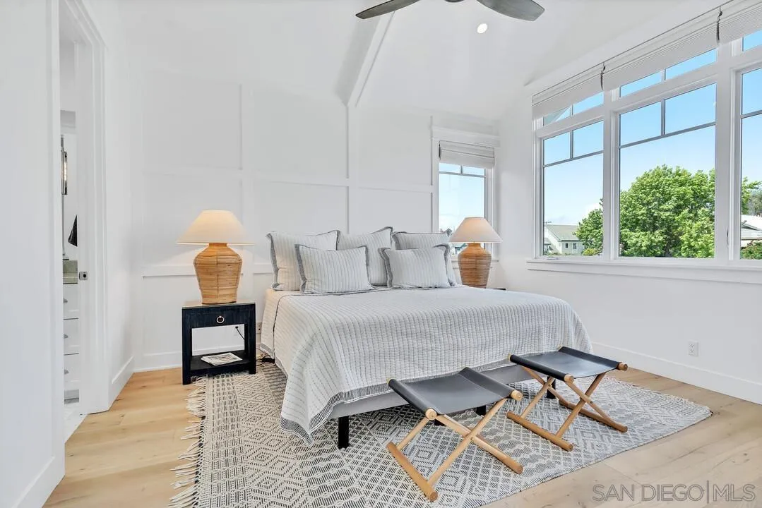 949 D Avenue Coronado, CA 92118 - Photo 12 of 28 a bedroom with a bed a mirror and lamp next to a window
