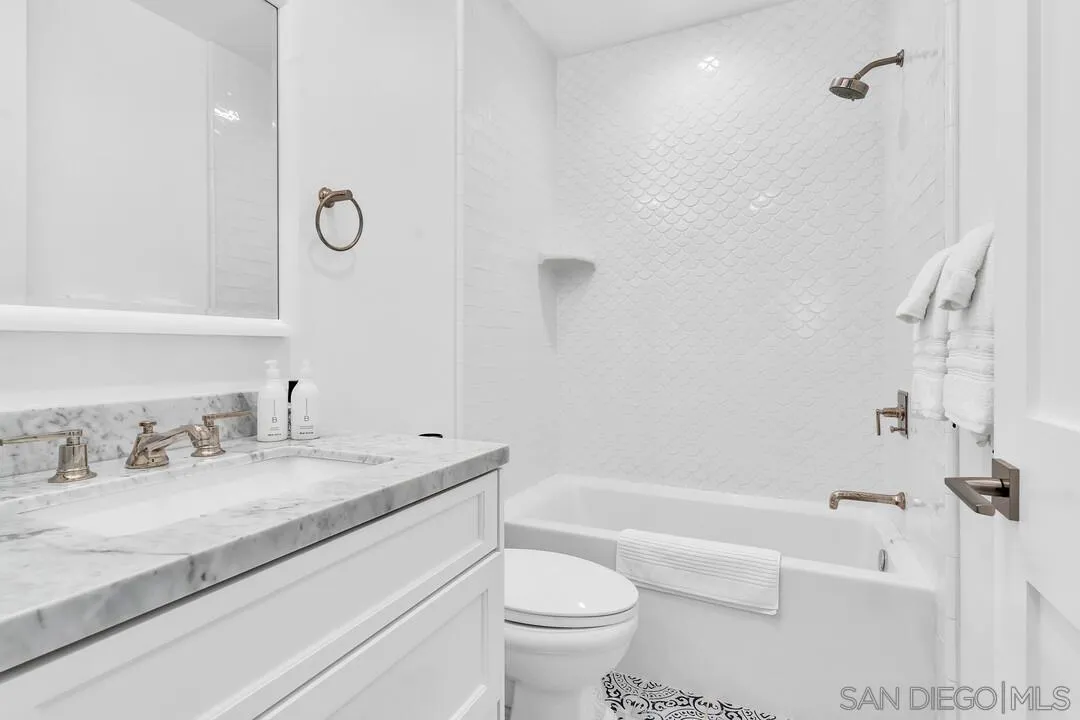 949 D Avenue Coronado, CA 92118 - Photo 17 of 28 a bathroom with a granite countertop sink a toilet and a bathtub