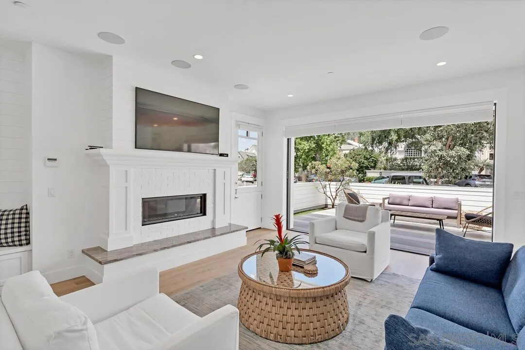 949 D Avenue Coronado, CA 92118 - Photo 4 of 28 a living room with furniture a fireplace and a large window