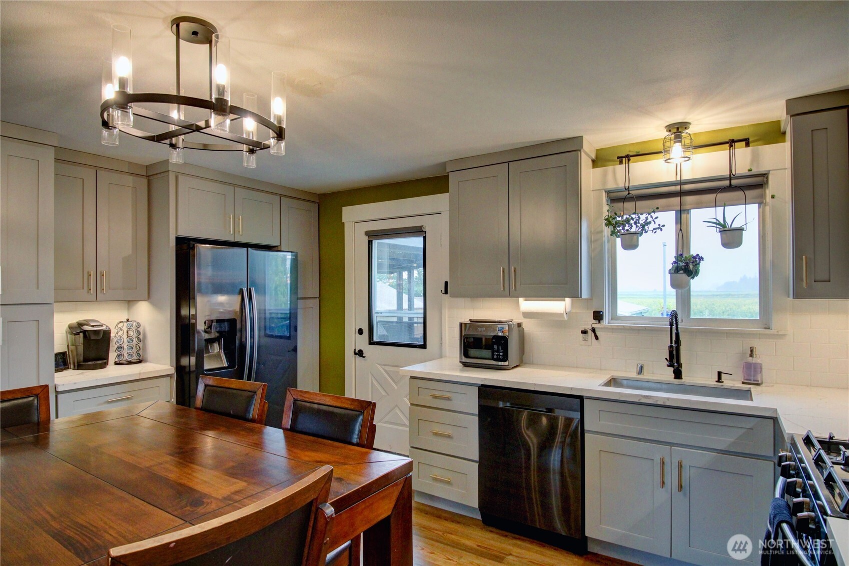 13168 Avon Allen Road Mount Vernon, WA 98273 - Photo 9 of 34 a kitchen with stainless steel appliances a table chairs and chandelier