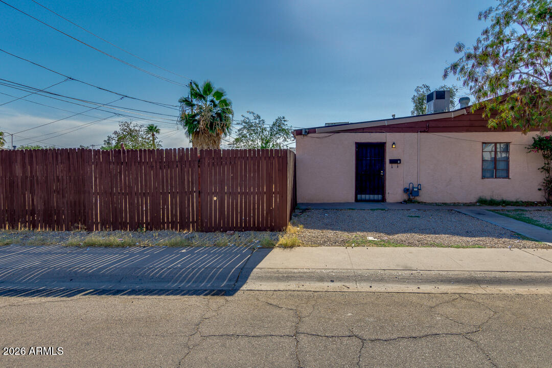 a view of backyard with wooden fence and potted plants