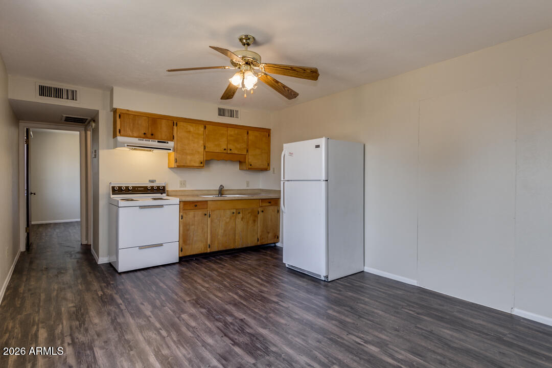 1301 West Indian School Road, Unit B Phoenix, AZ 85013 - Photo 3 of 9 a kitchen with a refrigerator a sink and dishwasher with white cabinets